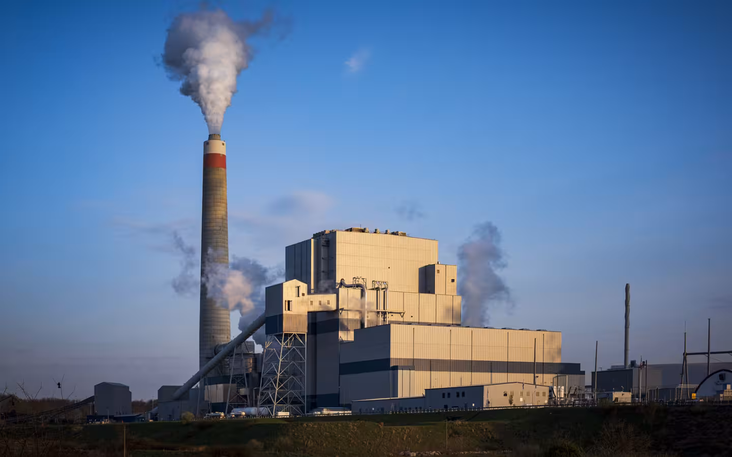 Longview Power Plant with steam rising from its chimney against a blue sky