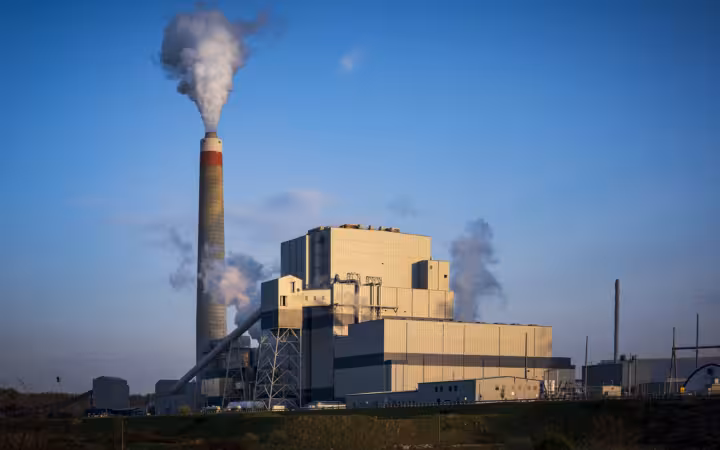 Longview Power Plant with steam rising from its chimney against a blue sky
