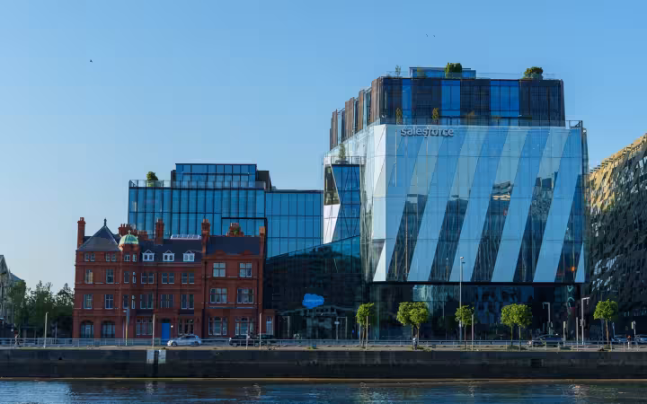 Salesforce’s Dublin office overlooks the River Liffey beside red-brick buildings.