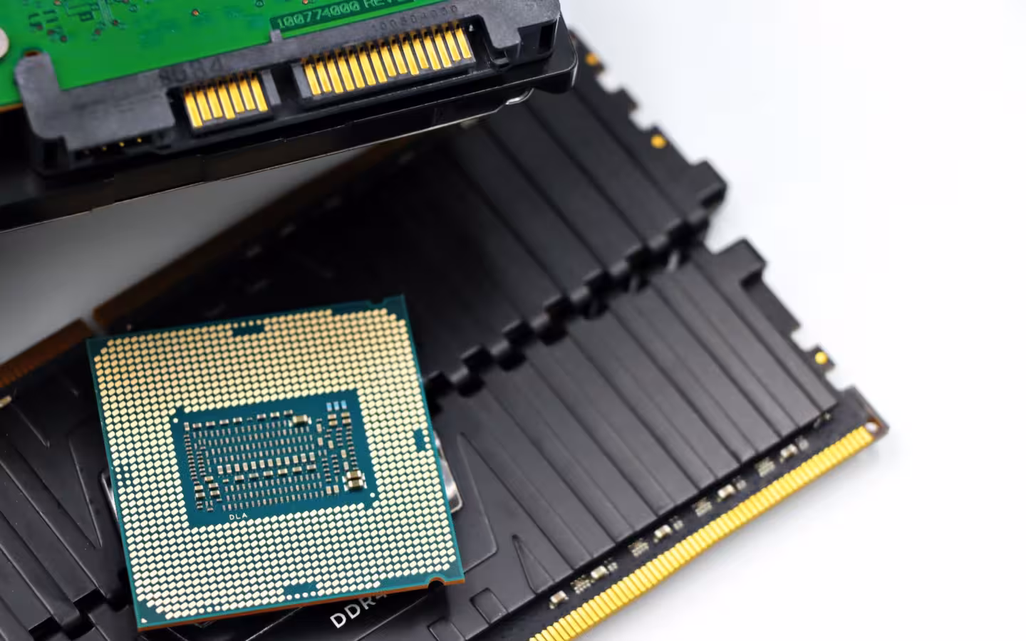 A CPU chip lies on RAM modules beneath a hard-drive connector.