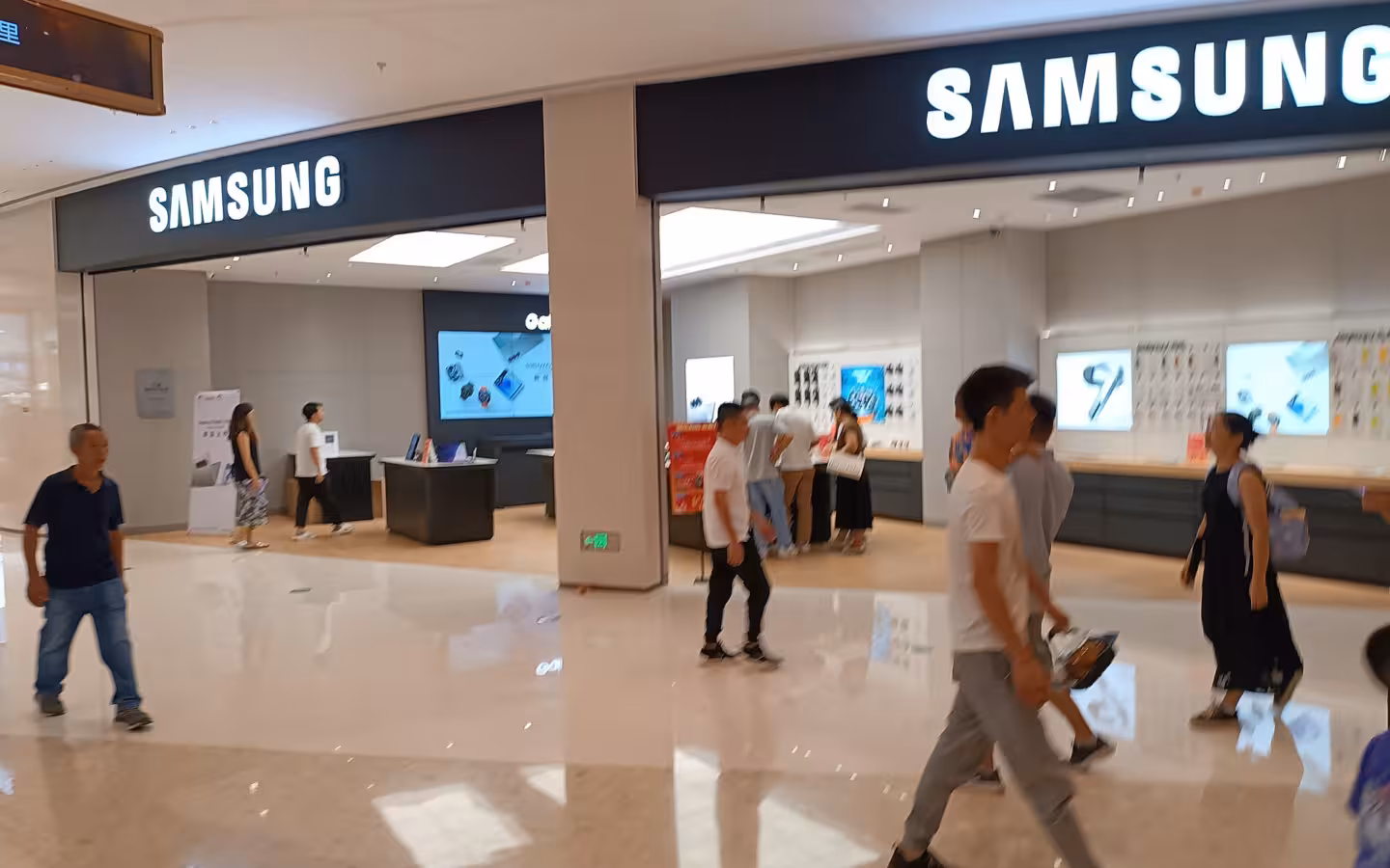 A Samsung Electronics store in Zhongshan, with shoppers crossing the mall foreground.
