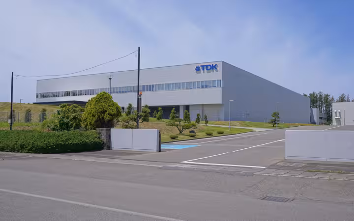 TDK Inakura Factory west site behind an empty road and landscaped grounds