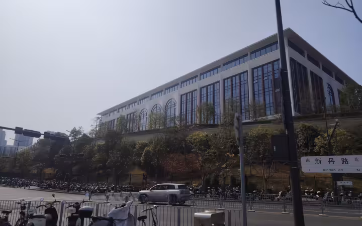 Huawei Guanlan campus building above a road lined with parked scooters.