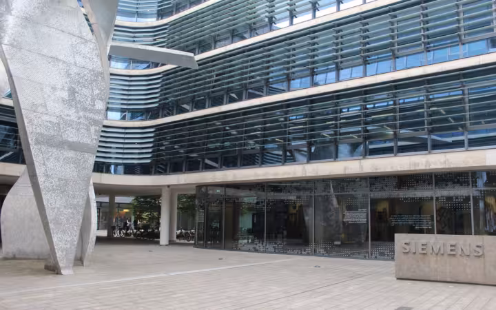 Siemens AG corporate headquarters in Munich, with a glass facade and Siemens sign