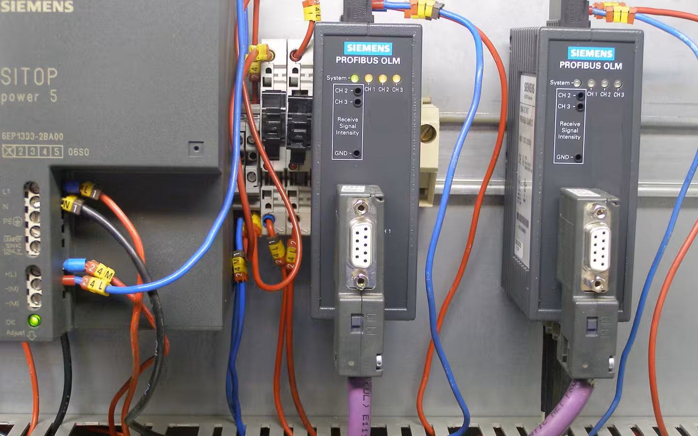 Siemens automation modules mounted on a rail amid red and blue wiring