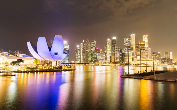 Singapore's illuminated skyline and waterfront buildings reflected in the bay at night