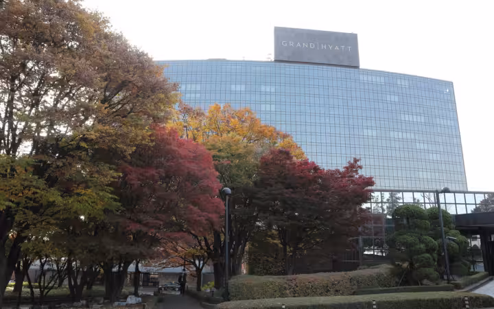 Grand Hyatt Seoul exterior behind autumn trees and landscaped grounds.