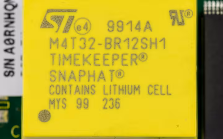 A yellow STMicroelectronics TIMEKEEPER battery module mounted on a circuit board