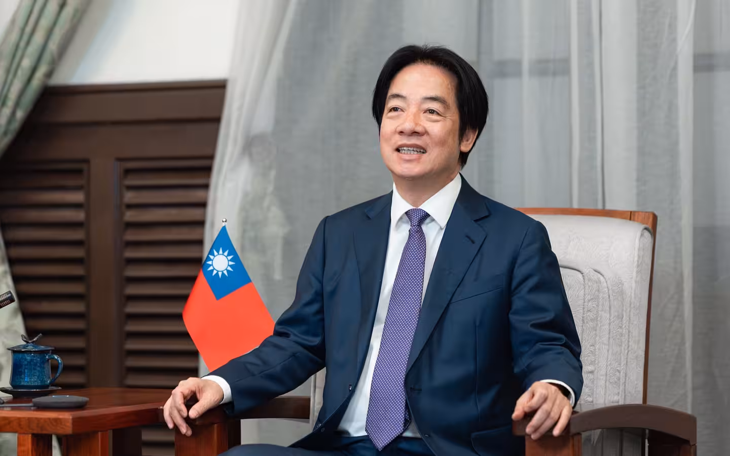 President Lai sits in a chair beside a Taiwanese flag.