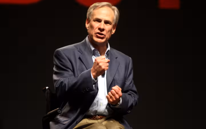 Greg Abbott gestures while speaking onstage at FreePac in Phoenix, Arizona.