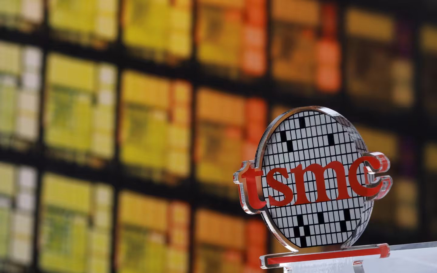 A TSMC logo at its Hsinchu headquarters, with colorful windows behind it