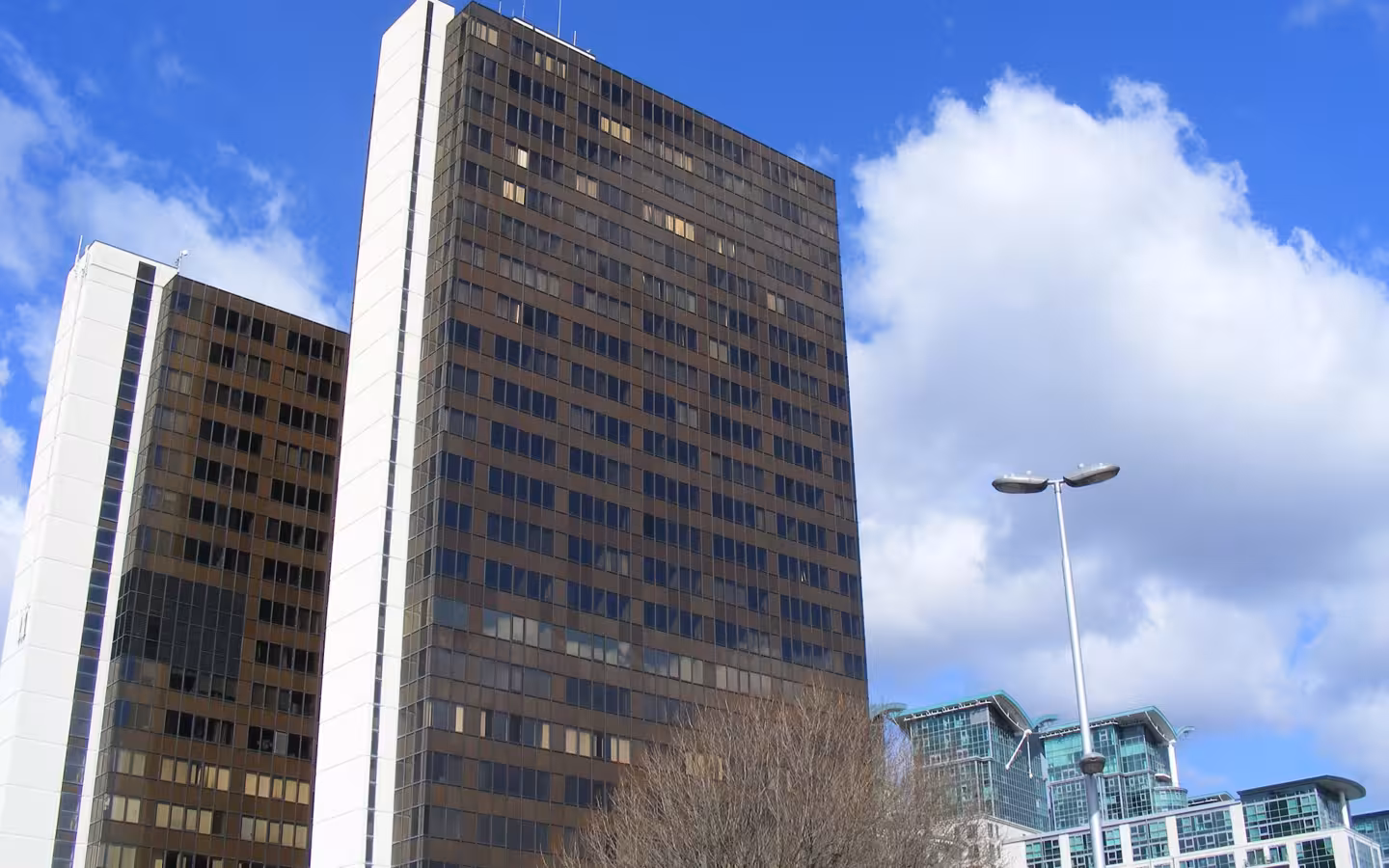 Market Towers in Vauxhall beneath a blue sky, with trees and a streetlight.