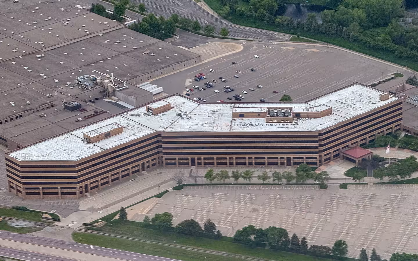 An aerial view of the Thomson Reuters office building in Minnesota with surrounding parking lots.
