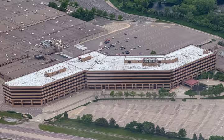 An aerial view of the Thomson Reuters office building in Minnesota with surrounding parking lots.