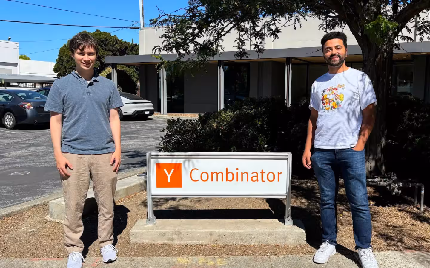 VideoGen co-founders Anton Koenig and David Grossman stand either side of a Y Combinator sign