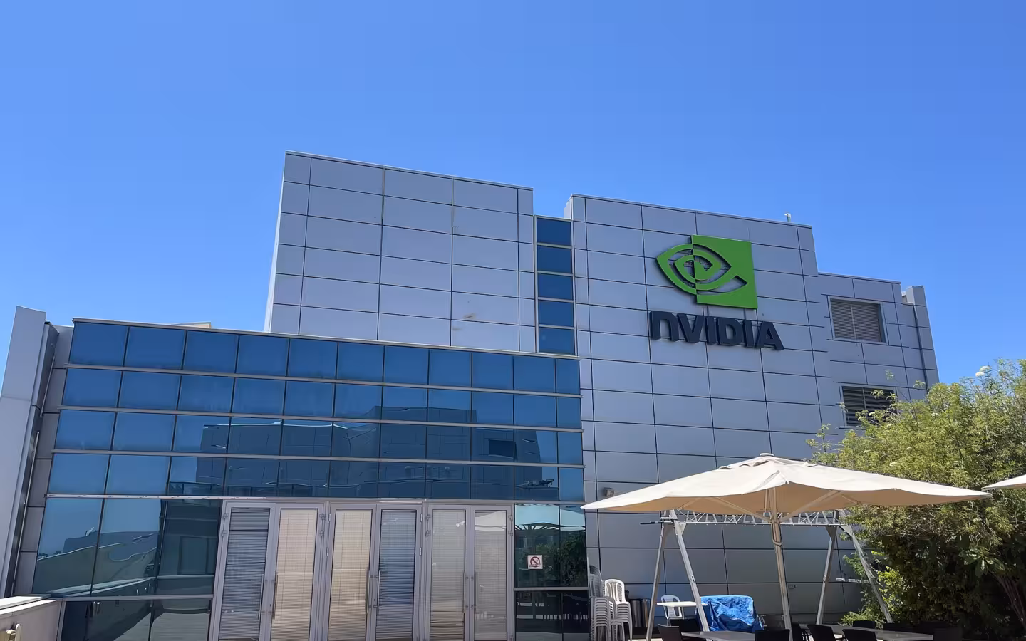 Nvidia's Ra'anana office building under a blue sky, with patio seating outside