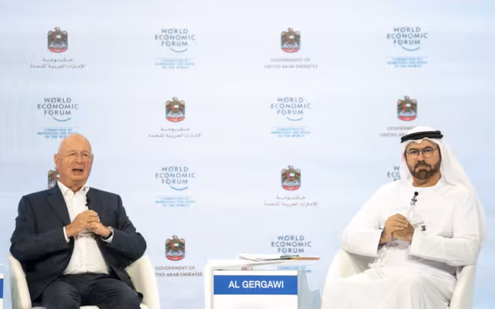 Klaus Schwab and Mohammad Al Gergawi seated before World Economic Forum logos