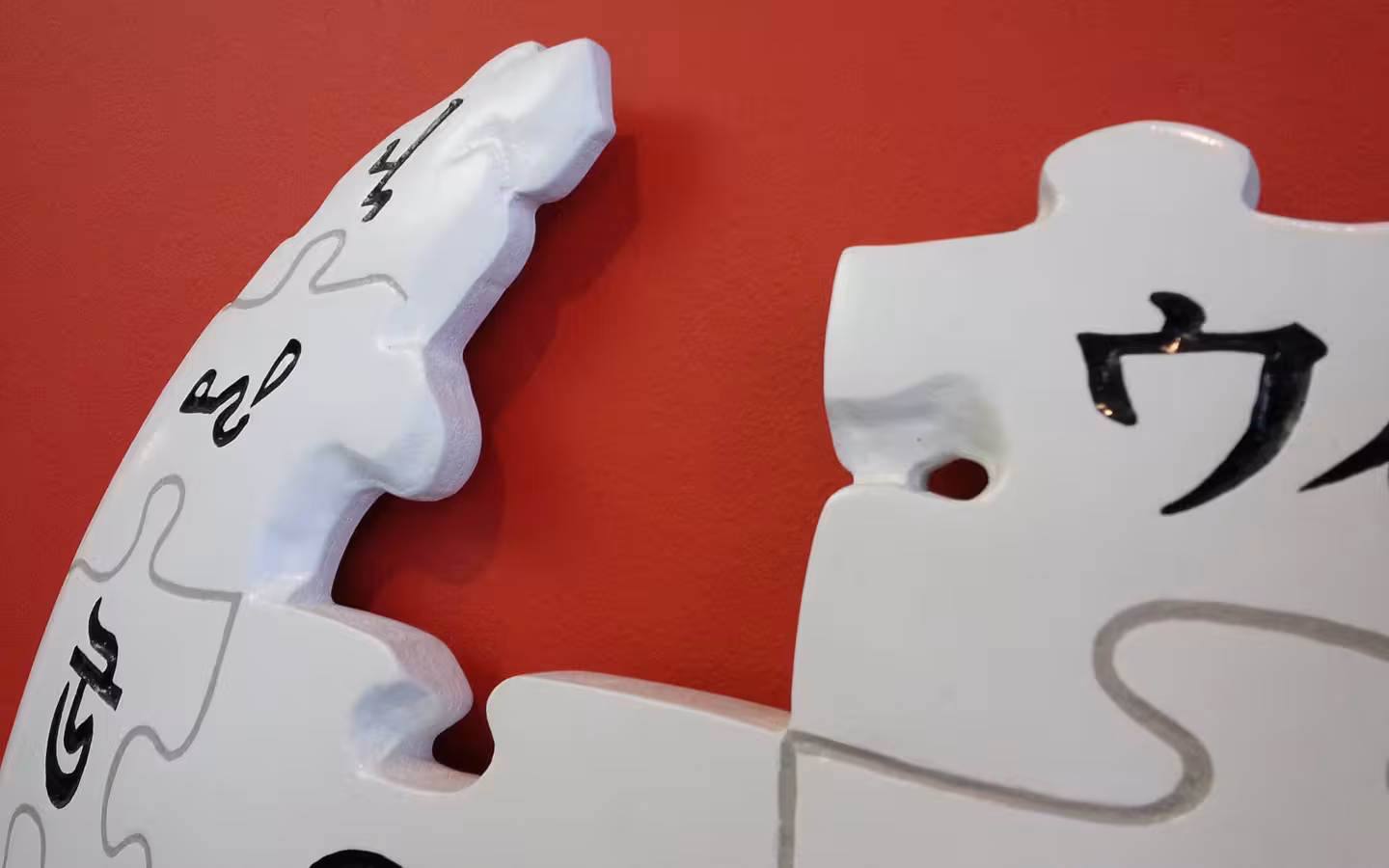 Close-up of the relief Wikipedia puzzle-globe logo on a red office wall